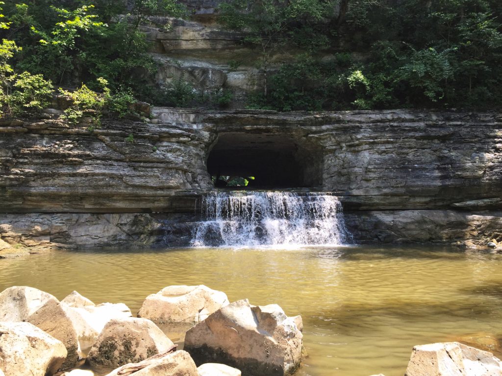Waterfall through tunnel at Warpath River State Park, Nashville